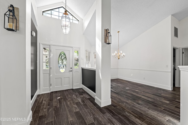 foyer featuring high vaulted ceiling, a chandelier, visible vents, and plenty of natural light