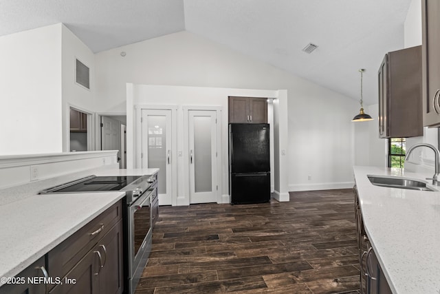 kitchen featuring vaulted ceiling, a sink, stainless steel range with electric cooktop, visible vents, and freestanding refrigerator