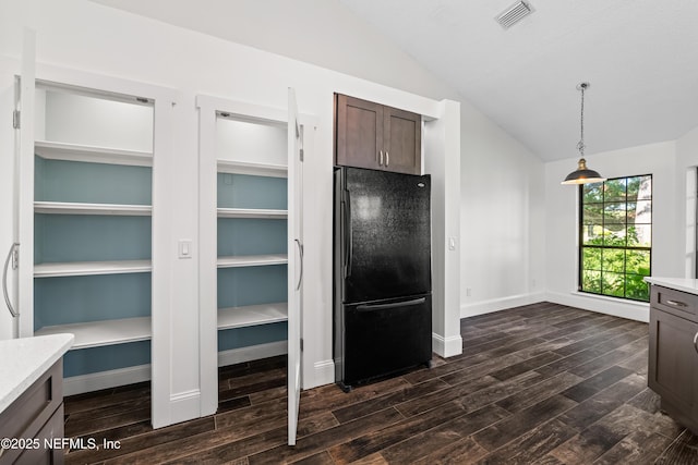 kitchen featuring dark brown cabinetry, light countertops, lofted ceiling, dark wood-style floors, and freestanding refrigerator