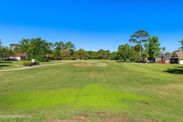 surrounding community featuring golf course view and a lawn