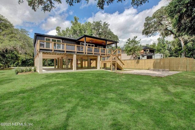 rear view of house featuring a patio area, a wooden deck, stairway, and a yard