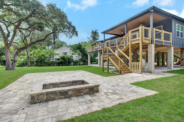 rear view of house with a patio area, a lawn, a ceiling fan, and stairs