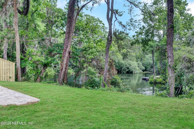 view of yard with a floating dock and a water view