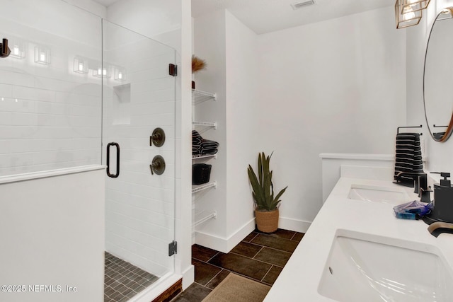 full bathroom featuring a sink, a shower stall, and double vanity