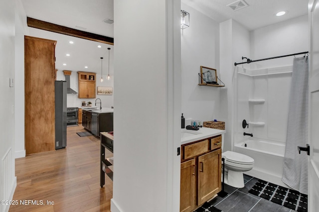 bathroom with shower / bath combination with curtain, toilet, vanity, and visible vents