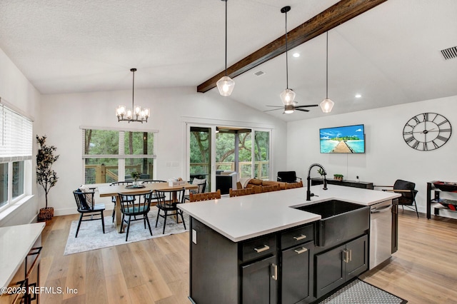kitchen with dishwasher, a healthy amount of sunlight, a sink, light wood-style floors, and lofted ceiling with beams