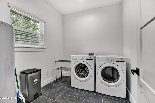 washroom featuring washing machine and clothes dryer, laundry area, and dark tile patterned flooring
