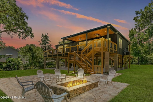 view of patio / terrace with a fire pit, central air condition unit, a ceiling fan, stairway, and a deck