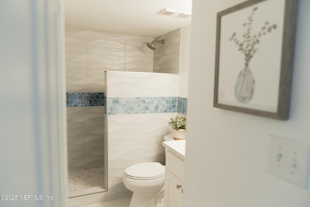661 Ponte Vedra Blvd Unit 661B, Ponte Vedra Beach, FL 32082 - bathroom featuring tiled shower, tile walls, toilet, vanity, and visible vents