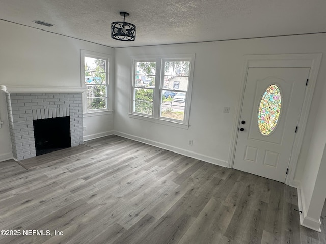 4848 Sappho Ave, Jacksonville, FL 32205 - entrance foyer with visible vents, wood finished floors, a textured ceiling, and a brick fireplace