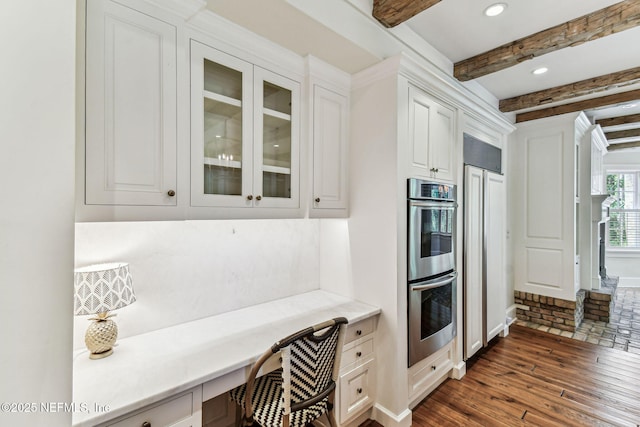 6230 Highlands Ct, Ponte Vedra Beach, FL 32082 - kitchen featuring stainless steel double oven, dark wood-style flooring, glass insert cabinets, white cabinets, and beamed ceiling