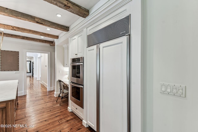 6230 Highlands Ct, Ponte Vedra Beach, FL 32082 - kitchen with paneled built in fridge, double oven, beamed ceiling, dark wood-style floors, and recessed lighting
