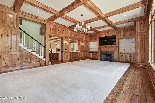 6230 Highlands Ct, Ponte Vedra Beach, FL 32082 - unfurnished living room featuring hardwood / wood-style floors, wood walls, beamed ceiling, a chandelier, and a fireplace