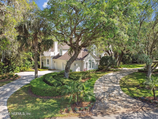 6230 Highlands Ct, Ponte Vedra Beach, FL 32082 - view of front facade featuring driveway, an attached garage, stucco siding, a balcony, and a chimney