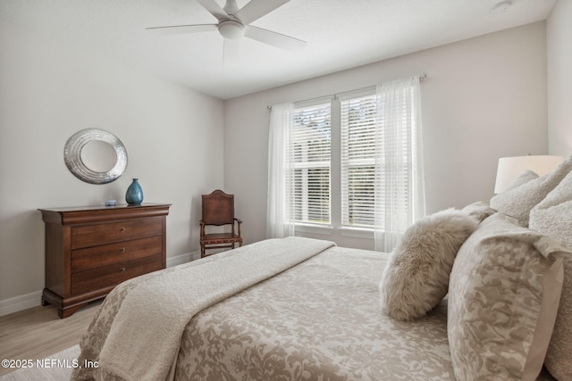 bedroom featuring wood finished floors, baseboards, and ceiling fan