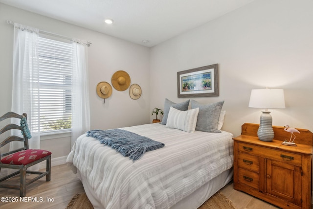 bedroom featuring light wood finished floors and baseboards
