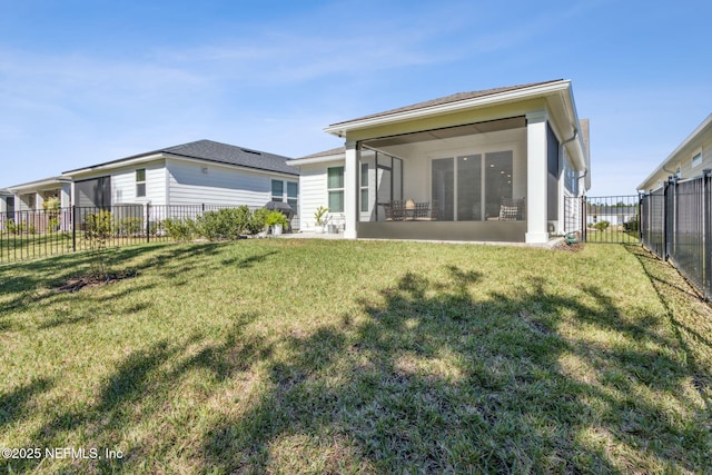 back of property featuring a fenced backyard, a sunroom, and a yard