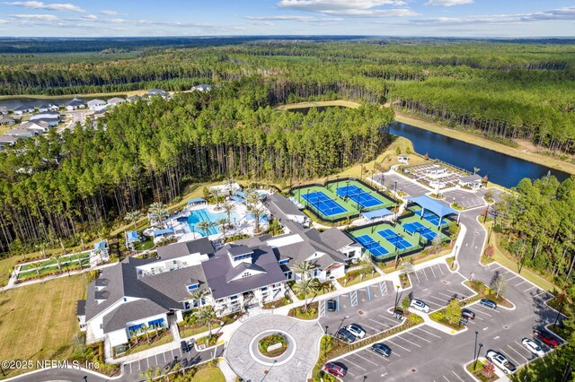 drone / aerial view with a wooded view and a water view