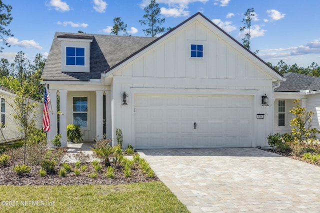 modern inspired farmhouse with roof with shingles, decorative driveway, board and batten siding, and a garage