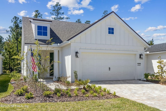 modern inspired farmhouse with board and batten siding, a shingled roof, a garage, and decorative driveway