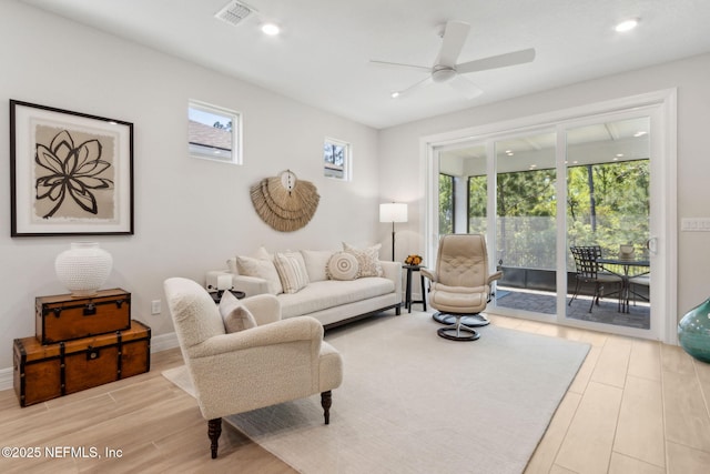 living area featuring wood finished floors, a ceiling fan, visible vents, and recessed lighting