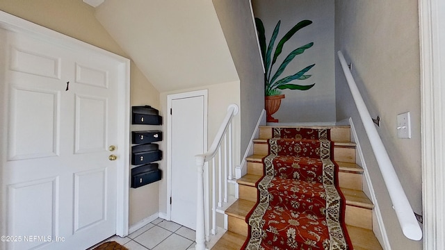 stairway featuring lofted ceiling and tile patterned floors