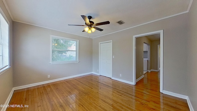 unfurnished bedroom featuring baseboards, visible vents, light wood-style floors, and multiple windows
