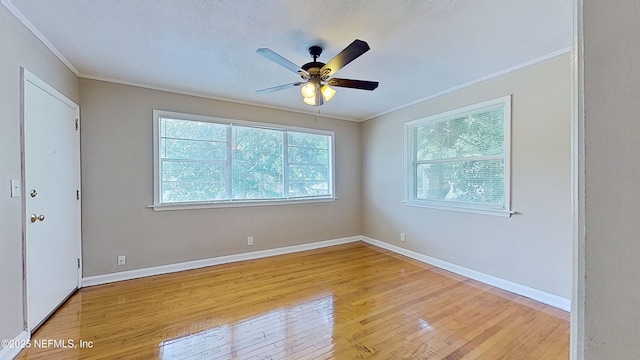 unfurnished room with baseboards, wood finished floors, ceiling fan, and crown molding