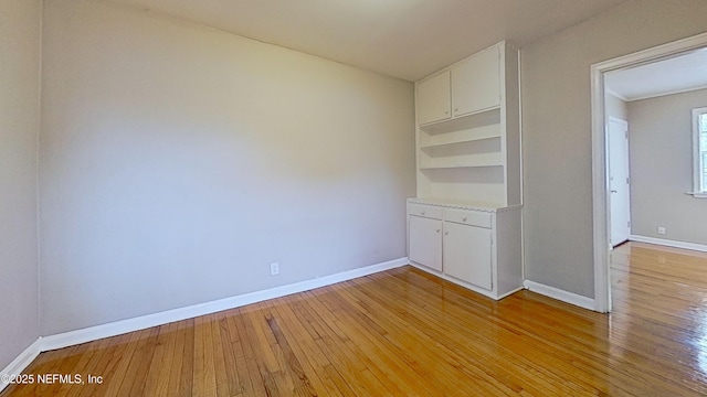 spare room with light wood-style floors and baseboards
