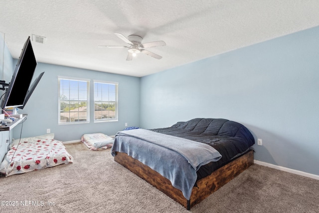 carpeted bedroom featuring visible vents, a ceiling fan, baseboards, and a textured ceiling