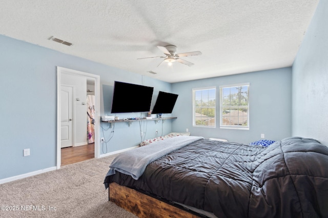 carpeted bedroom featuring baseboards, a ceiling fan, visible vents, and a textured ceiling