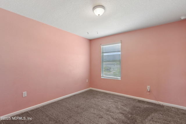 empty room featuring baseboards and carpet
