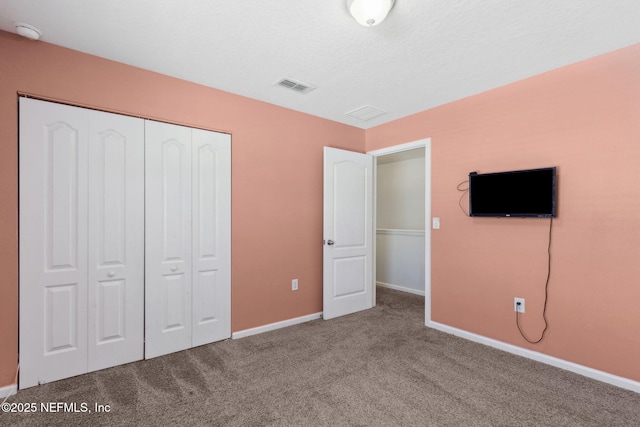 unfurnished bedroom featuring a closet, visible vents, carpet flooring, and baseboards