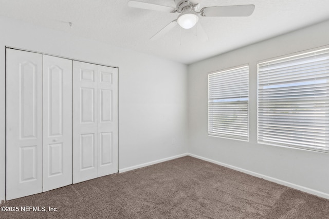 unfurnished bedroom featuring carpet floors, a closet, a ceiling fan, and baseboards