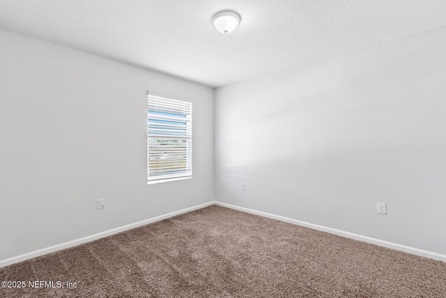 carpeted spare room with baseboards