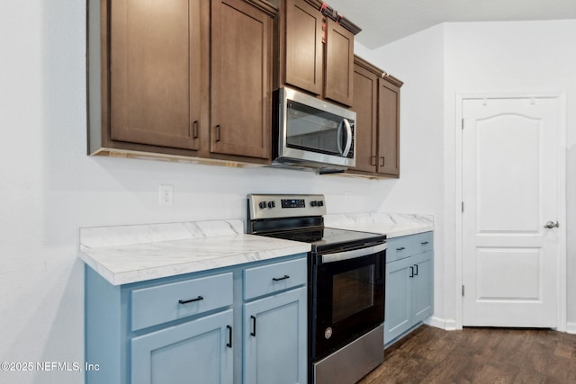 kitchen featuring light countertops, dark wood finished floors, and appliances with stainless steel finishes