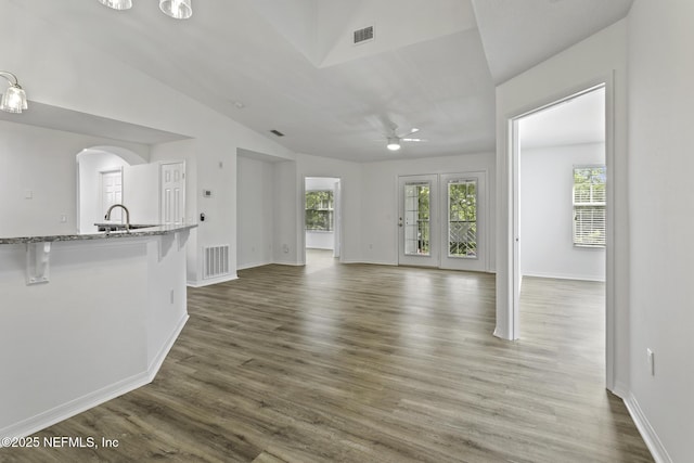 11213 Harbour Vista Cir, Saint Augustine, FL 32080 - unfurnished living room featuring arched walkways, ceiling fan, vaulted ceiling, and visible vents