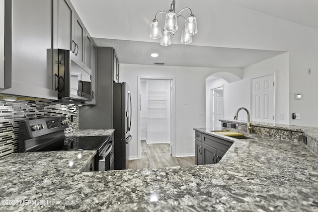 11213 Harbour Vista Cir, Saint Augustine, FL 32080 - kitchen with dark stone countertops, tasteful backsplash, a sink, light wood-style flooring, and appliances with stainless steel finishes