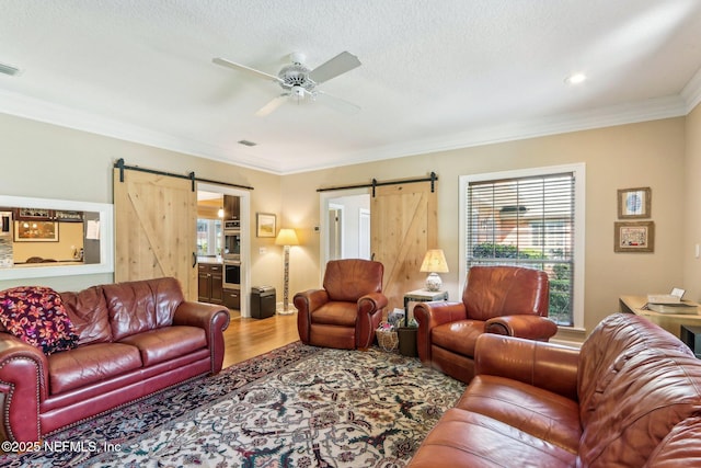 2942 Mandarin Hollow Dr, Jacksonville, FL 32257 - living area with crown molding, a barn door, ceiling fan, and wood finished floors