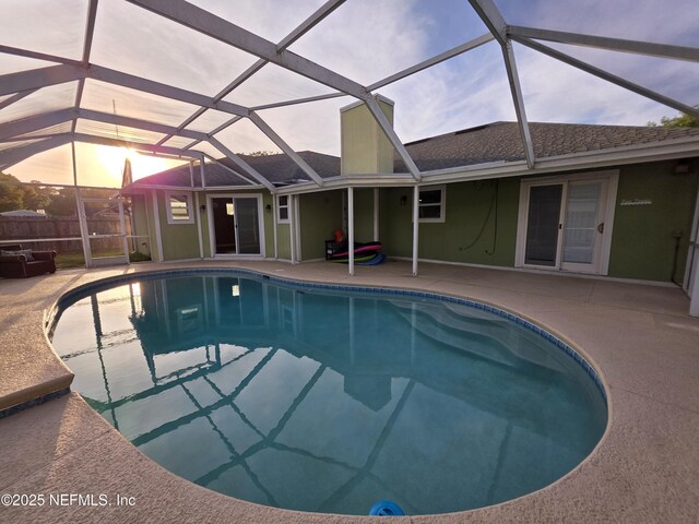 view of pool featuring a patio, glass enclosure, and a fenced in pool