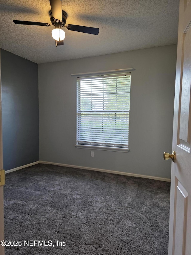 carpeted spare room with a textured ceiling, a ceiling fan, and baseboards