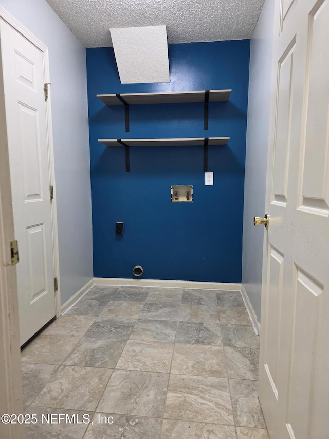 laundry area with washer hookup, a textured ceiling, laundry area, and baseboards
