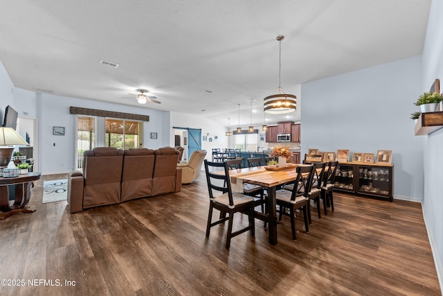 dining area featuring ceiling fan, visible vents, and dark wood-type flooring