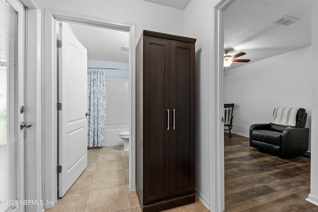 corridor featuring visible vents and a textured ceiling