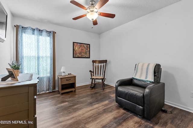 living area with dark wood-type flooring, baseboards, and ceiling fan