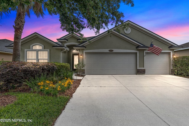 single story home featuring a garage, stucco siding, and driveway
