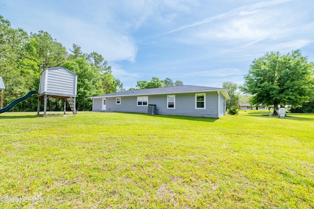 rear view of house featuring a yard