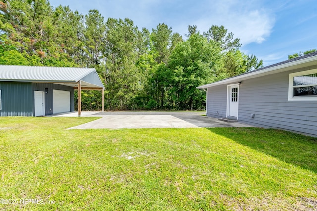 view of yard with an outbuilding, a detached garage, and concrete driveway