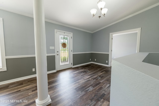 unfurnished dining area featuring dark wood-type flooring, crown molding, and ornate columns