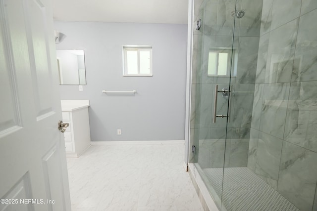full bath featuring baseboards, vanity, marble finish floor, and a stall shower